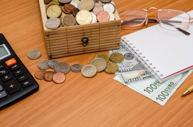 Hazine sandığı madeni para ile açın. Bize dolar ve euro boş not defteri, gözlük ve hesap makinesi