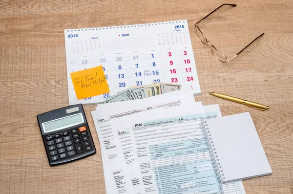 Tax form with calendar, pen, calculator, notepad and glasses