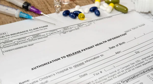 Medical patient form with pills and  syringes on  table