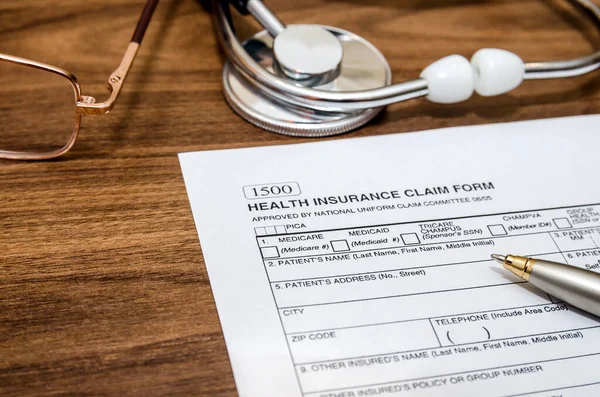 health insurance claim form and stethoscope