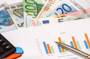 hesap makinesi ve renkli grafik grafik üzerinde kalem