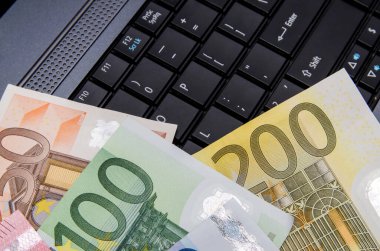 Dizüstü bilgisayarın üzerinde Euro banknotları