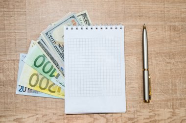 Arkaplan olarak farklı dolar ve avro içeren boş not defteri