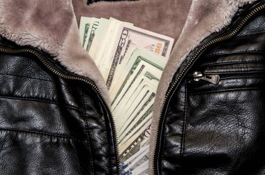 Deri ceketin cebinde dolar banknotları var.