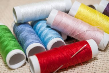 İğneyle dikmek için çok renkli gökkuşağı iplikleri.