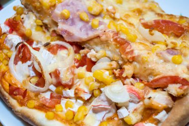 Domatesli pizza, tavuk, mısır, yengeç çubuğu ve peynir.