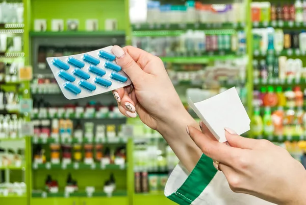 Eczanede reçeteli ve haplı kadın eczacının eli.
