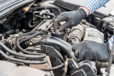 Car engine with worker hands close up