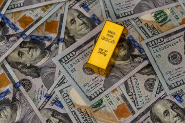 Dolarlık banknotları olan bir külçe altın.