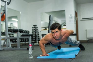 Spor salonunda şınav çeken bir sporcu.