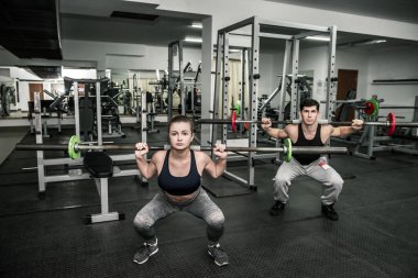 Her ikisi de dambıl tutan iki kadın eğitmen.