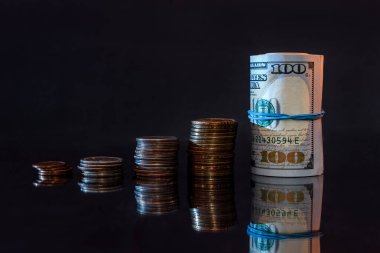 Koyu arkaplanda dolar banknotları ve paralar