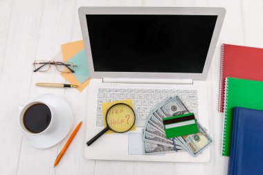 Kredi kartlı dolarlar ve klavyede büyüteç. 