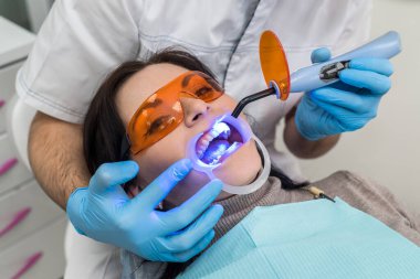 Lambalı eller ve koruyucu gözlüklü hasta.