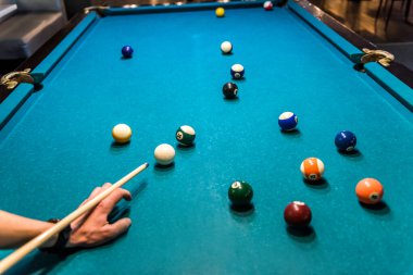 Masada bilardo topuna nişan almış bir el.