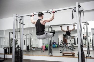 Adam jimnastik salonunda bazı egzersizler yapıyor.