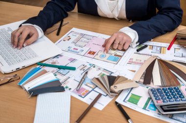 Renkler, bir dizüstü bilgisayar ve bir plan binanın örnekleri ofisteki Tasarımcısı çalışır