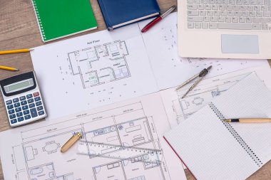 Dizüstü bilgisayarı, hesap makinesi ve kalemleriyle ev planının en üst görüntüsü