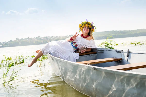 美しい女の子で民族衣装でボートで湖 — ストック写真