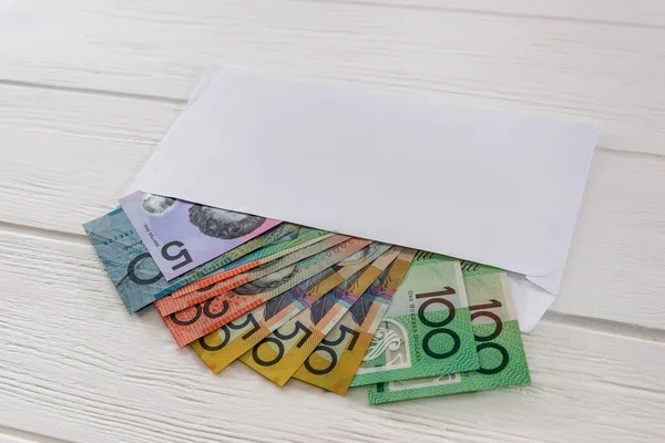 Australian dollars in envelope on wooden desk