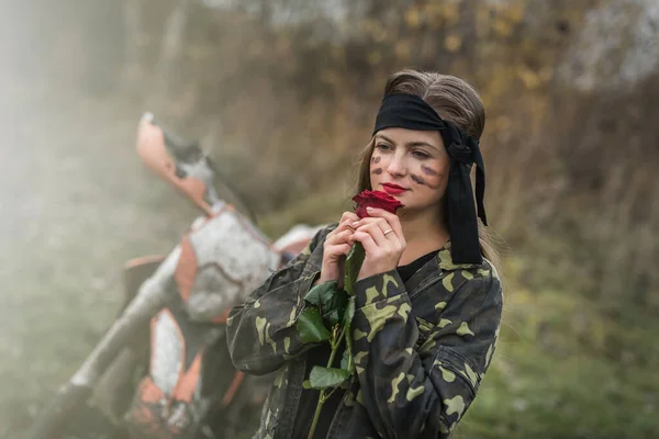 Woman warrior in camouflage form posing outdoors