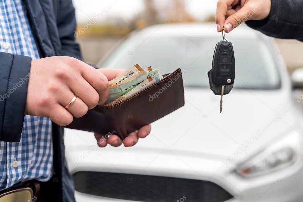 Male hands with wallet and female hands with keys from car