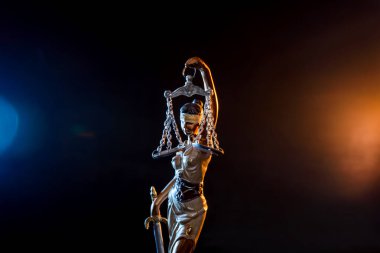 Karanlık arka planda Adalet Tanrıçası heykeli 