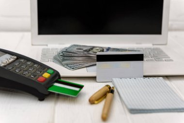 Banka terminali ve dolar banknotları olan dizüstü bilgisayar