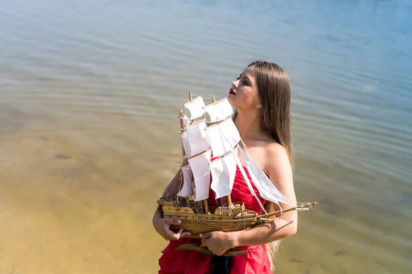 Kvinna Röd Klänning Med Båt Modell Stranden — Stockfoto