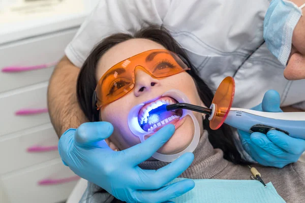 Whitening procedure to patient in dentistry with lamp