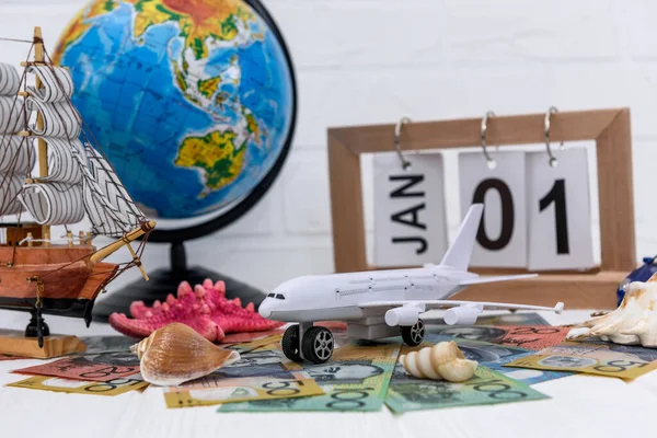 Toy airplane with globe and australian dollar banknotes