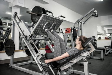 Spor malzemelerinde beden eğitimi alan genç bir kadın.