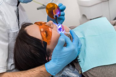 Lambalı eller ve koruyucu gözlüklü hasta.