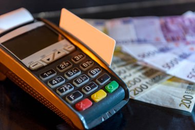 Arkasında kart ve avro banknotları olan terminal