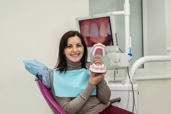 Woman smiling in dentistry with jaw model