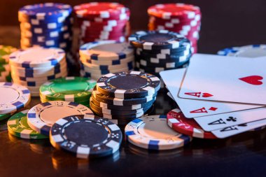Siyah arkaplanda poker çipleri ile kart oynamak