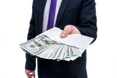 Elinde dolar banknotları ve zarf tutan bir iş adamı.