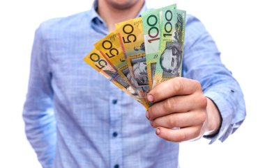 Erkek el, beyaza izole edilmiş Avustralya doları banknotları sunuyor.