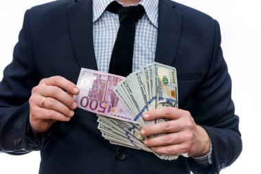 Dolar yığınları arasında euro banknotunu gösteren adam
