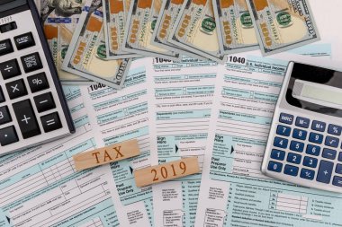 Dolar banknotları ve tahta küpleri olan 1040 vergi formu.