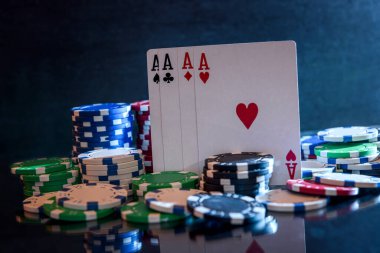 Siyah arkaplanda poker çipleri ile kart oynamak