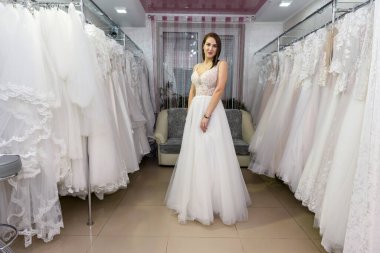 Gelinlikli mutlu gelin kuaförde duruyor.