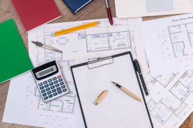 Ev planı, dizüstü bilgisayarı ve hesap makinesi olan mimarın iş yeri