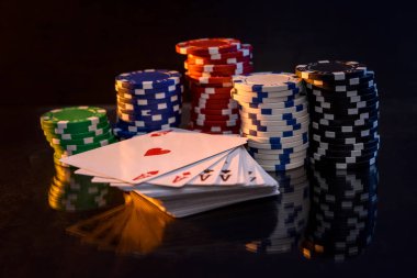 Siyah arkaplanda poker çipleri ile kart oynamak