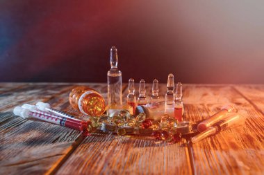 Ampuller ve şırıngalar ve ahşap arka planda araçlar