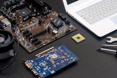 Tahta masanın üzerinde anakart olan dizüstü bilgisayar. Yakın plan.