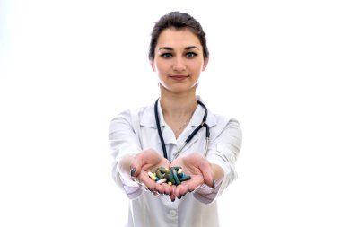 Avuçlarında renkli haplar olan doktor beyaza izole edilmiş.