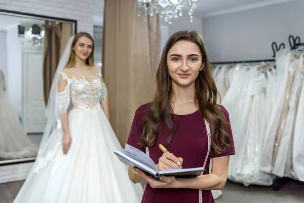 Дизайнер Блокнотом Невестой Свадебном Платье Позади — стоковое фото