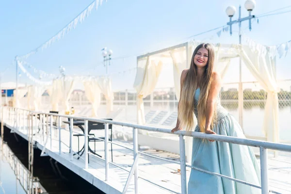 漂亮的姑娘穿着漂亮的薄荷裙站在码头上 — 图库照片