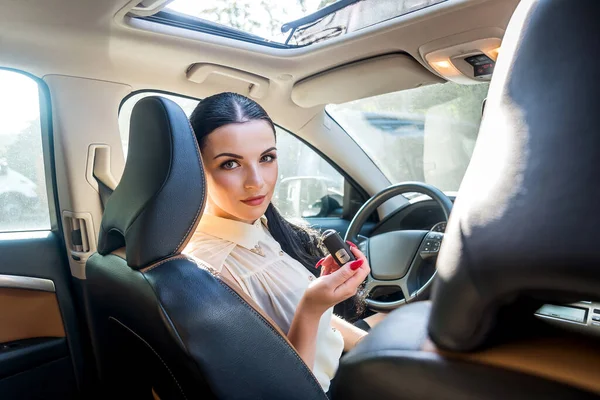 Mujer Sentada Dentro Coche Nuevo Ofreciendo Llave — Foto de Stock